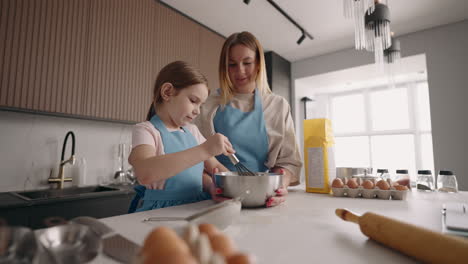 woman-and-her-little-helper-are-cooking-together-in-home-little-daughter-and-mother-are-making-cake